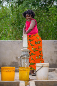 Femme africaine accédant à un point d'eau potable grâce aux programmes de World Vision France, symbole d'autonomisation féminine