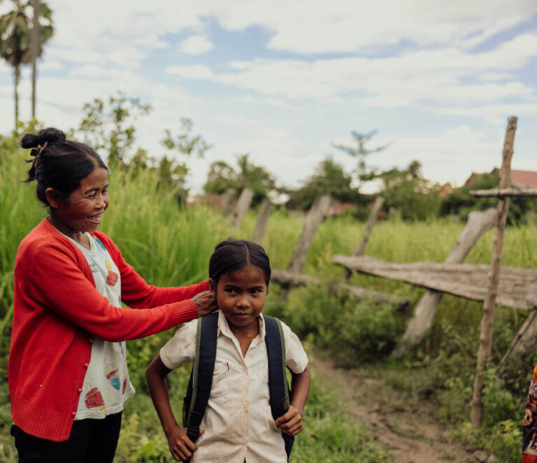 Mère et enfant devant une école fermée dans une zone rurale d'Asie